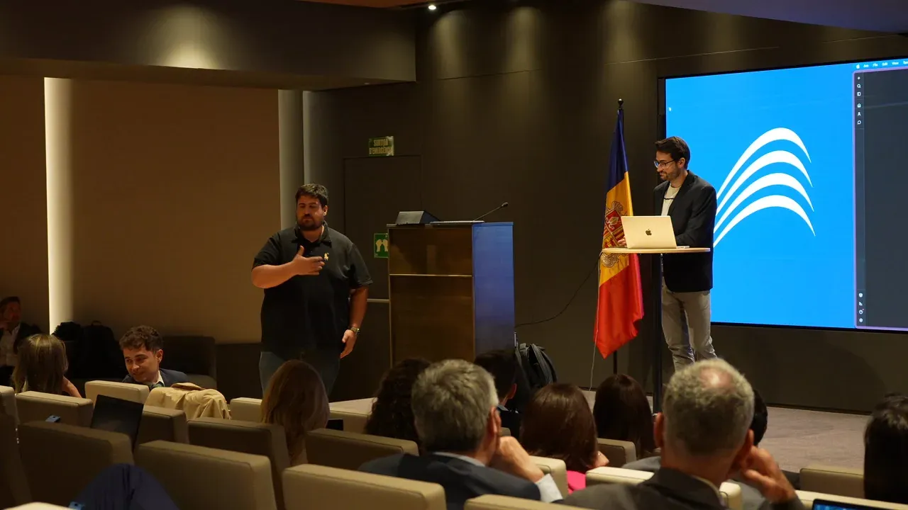 Two trainers at the front of an auditorium, with the staff seated and the client’s logo on the screen